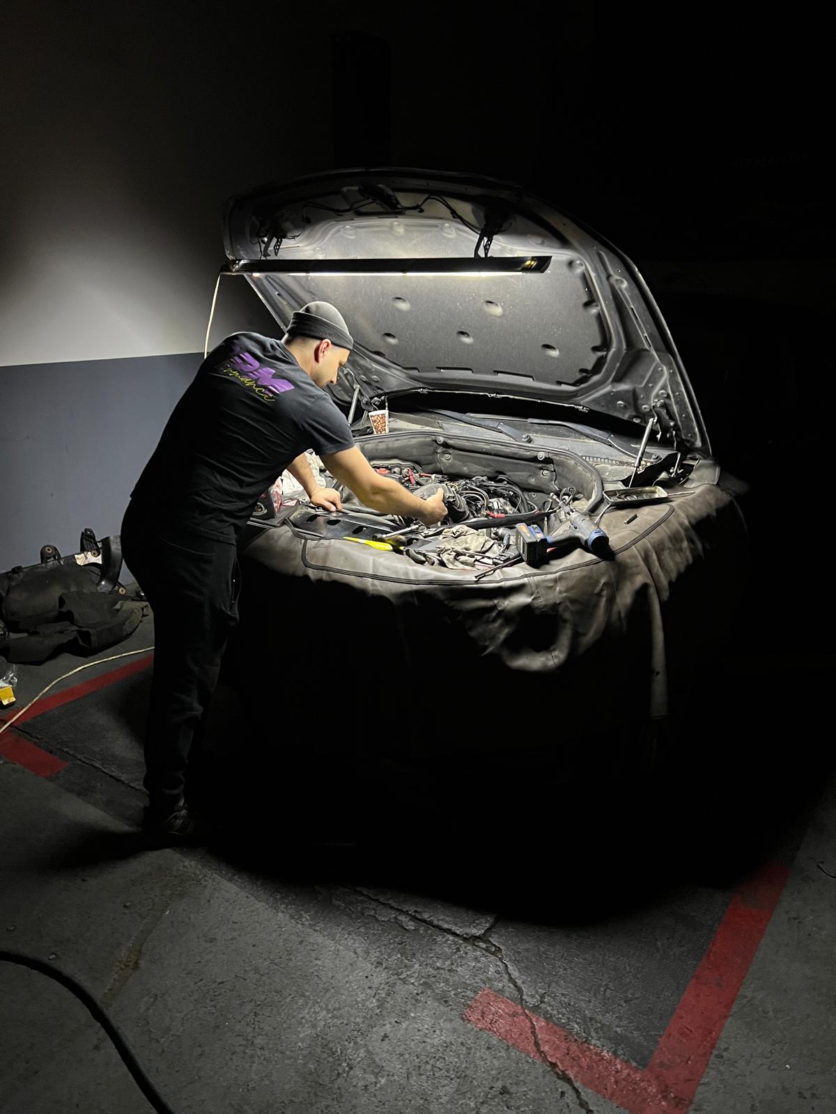 Inginer auto efectuând lucrari complexe pe un vehicul
